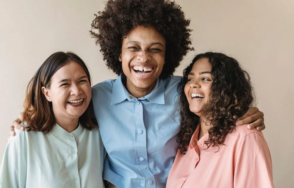 Three women laughing together at a party