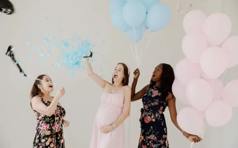 Three women laughing and popping confetti at a fun baby shower