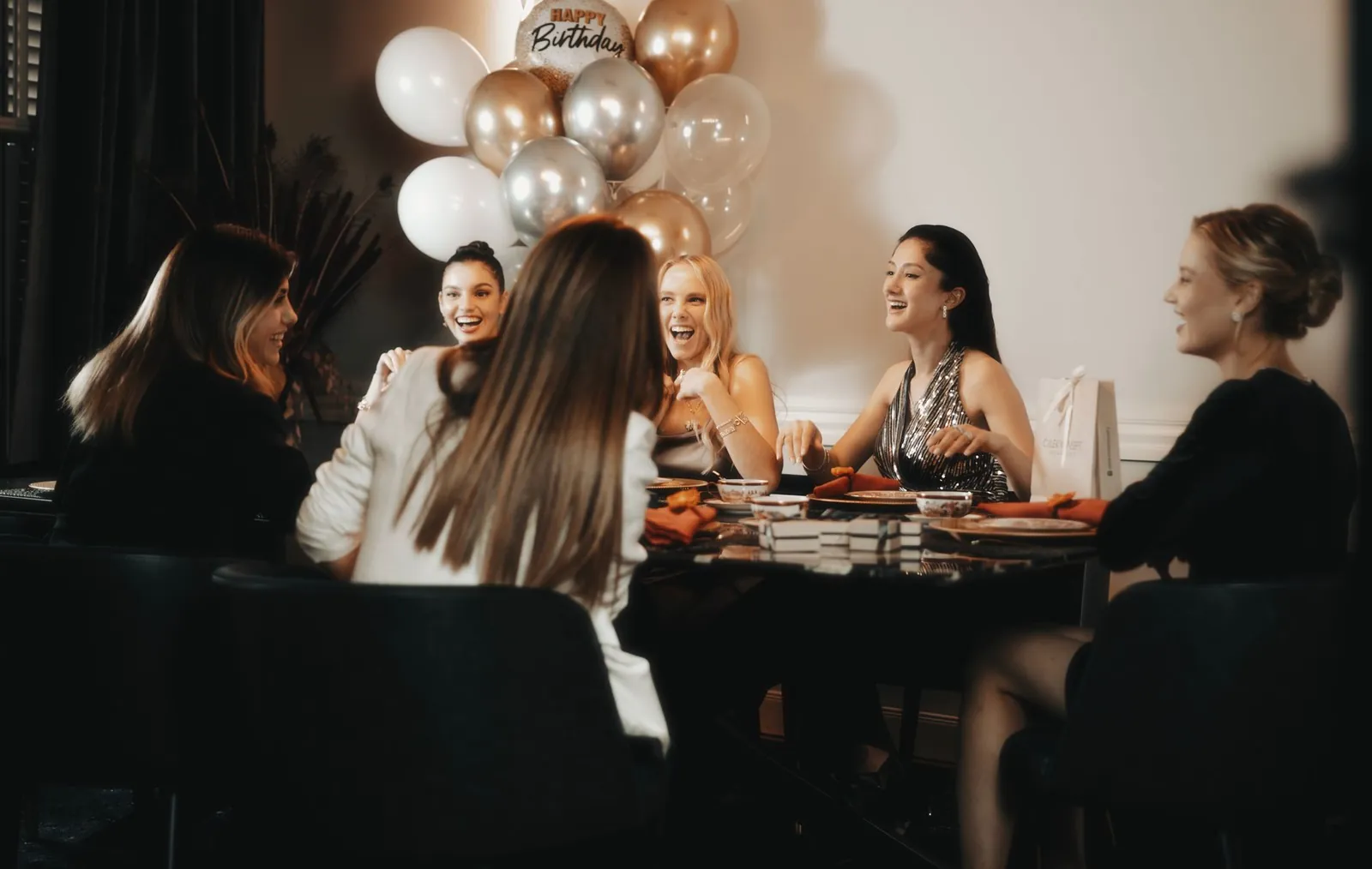 A large group of guests gathered around tables at a baby shower