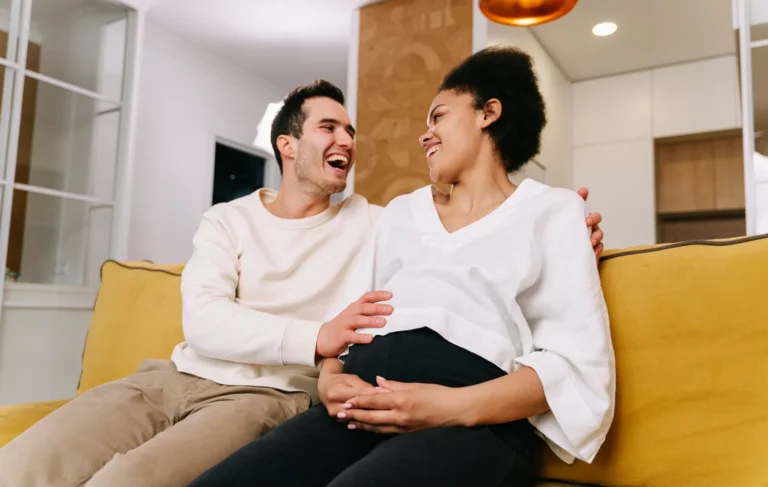 Expecting couple sitting together and smiling at their baby shower